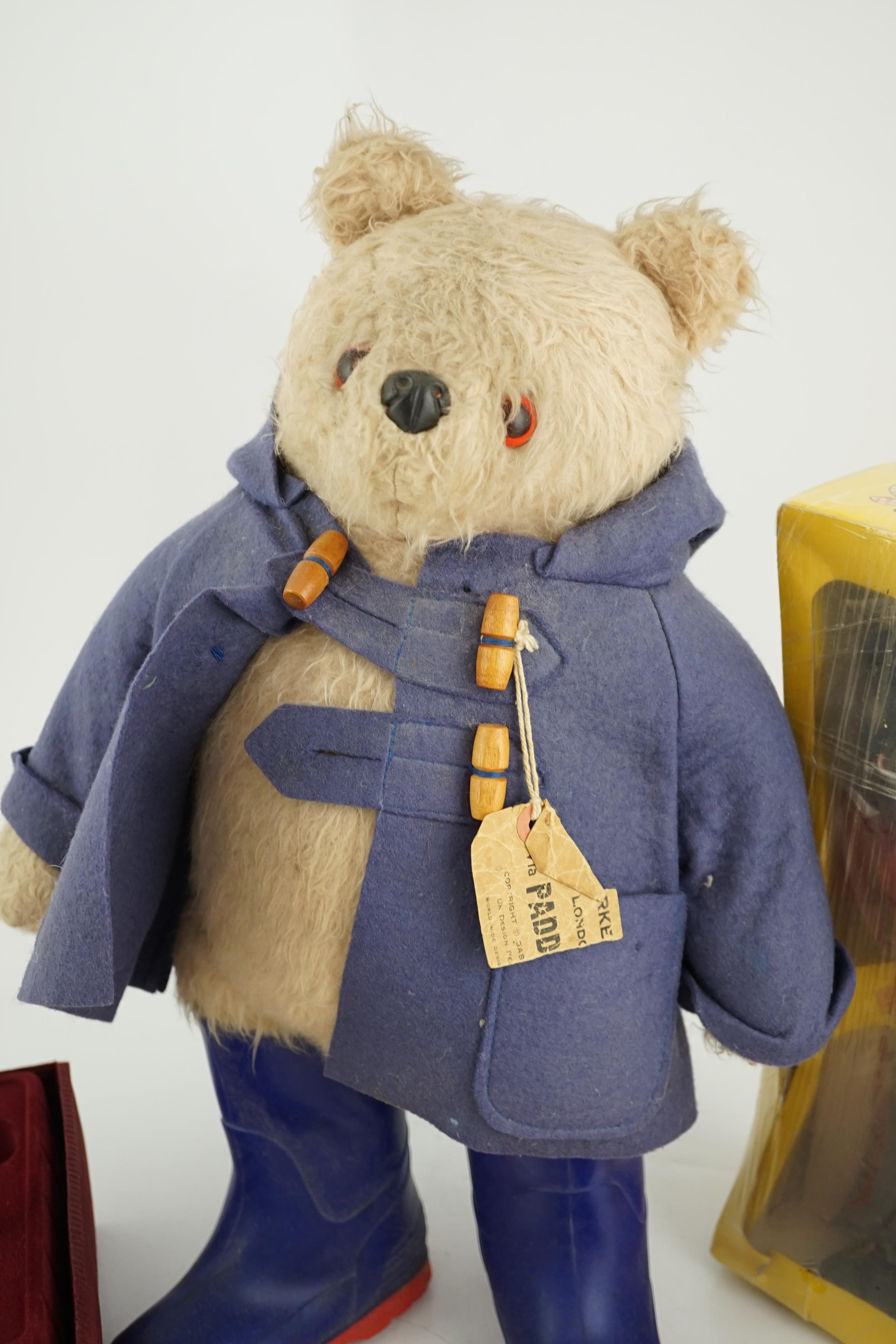 An early Paddington bear, blue jacket, missing hat, a Steiff Ltd. edition lilac bear in box, and a porcelain Pelham puppet in box, good condition